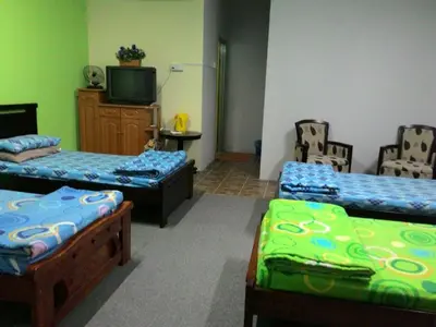 a room with two beds and a tv in it at Happy Owl in Ipoh