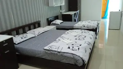 a bedroom with two beds with cats on them at ANTZ Village Studio in Kampar
