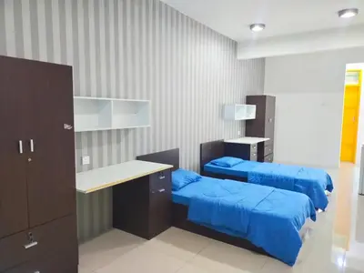 a room with two beds and a desk in it at ANTZ Village Studio in Kampar