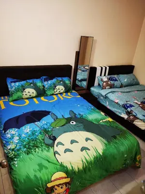 a bedroom with two beds with a large hello kitty blanket at Bidor Totoro and One piece animation house in Kampong Kuala Gepal
