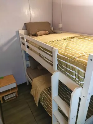 a bedroom with two bunk beds in a room at LUNAS DIY HOMESTAY in Lunas