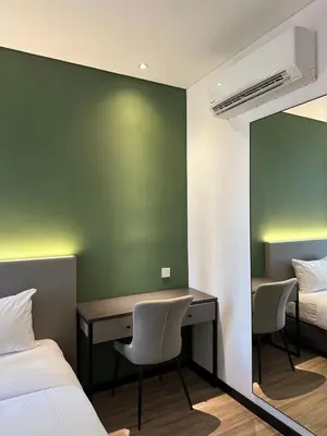 a bedroom with a desk and a bed and a desk and chairs at The Gallivant Hotel in George Town