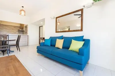 a blue couch in a living room with a mirror at EXECUTIVES Pantai Seaview Batu Ferringhi 2704 - 2 Bedrooms in Batu Ferringhi