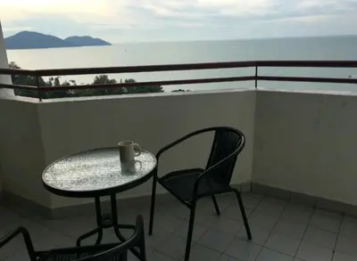a table and chairs on a balcony with the ocean at DELUXE Suite Seaview Batu Ferringhi 2304 - 2 Rooms in Batu Ferringhi
