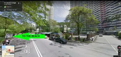 a street with a green sign that reads to the beach at DELUXE Suite Seaview Batu Ferringhi 2304 - 2 Rooms in Batu Ferringhi