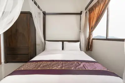 a bedroom with a bed and a window with curtains at DELUXE Suite Seaview Batu Ferringhi 2304 - 2 Rooms in Batu Ferringhi