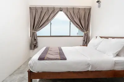 a bedroom with a large bed with a window at DELUXE Suite Seaview Batu Ferringhi 2304 - 2 Rooms in Batu Ferringhi