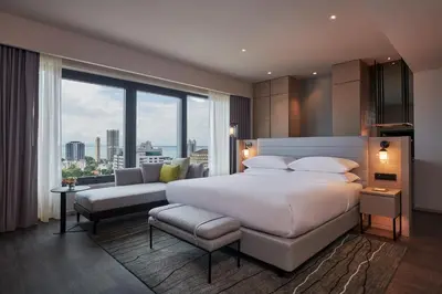 a bedroom with a large bed and a large window at Courtyard by Marriott Penang in George Town