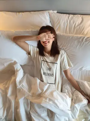 a woman laying in bed with her hands on her face at Courtyard by Marriott Penang in George Town