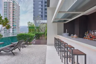 a view from the rooftop of a building with chairs and a pool at Courtyard by Marriott Penang in George Town