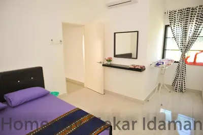 a bedroom with a bed and a mirror and a window at homestay mekar idaman in Kepala Batas