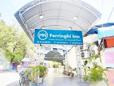 a sign for the entrance to a building with plants at MN Ferringhi Inn in Batu Ferringhi
