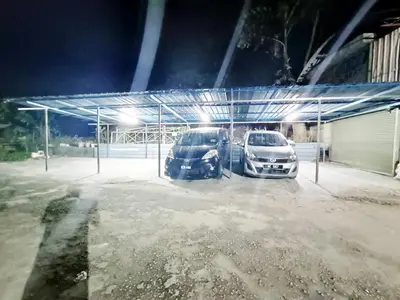 two cars parked in a parking lot at night at MN Ferringhi Inn in Batu Ferringhi