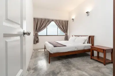 a bedroom with a bed and a window at Pantai Seaview Resort Batu Ferringhi 1801 - 3 Rooms in Batu Ferringhi