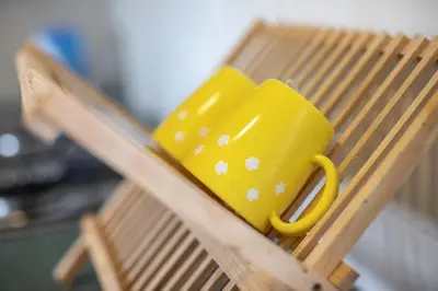 a yellow cup sitting on top of a wooden chair at Pantai Seaview Resort Batu Ferringhi 1801 - 3 Rooms in Batu Ferringhi