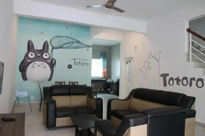 a waiting room with two couches and a wall with drawings at Bricks Terrace House 4R 3BR (Near to Night Market) in Brinchang