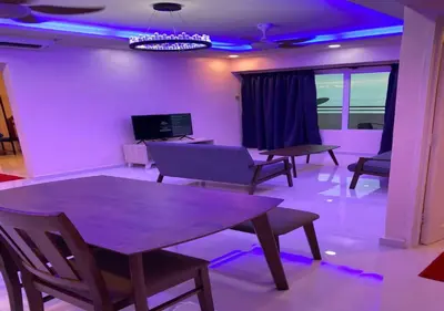 a living room with purple lighting and tables and chairs at My Suites Sri Sayang Resort in Batu Ferringhi