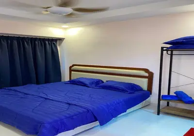 a bedroom with a bed with blue sheets and a ceiling at My Suites Sri Sayang Resort in Batu Ferringhi