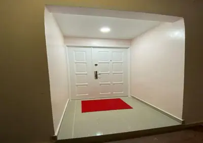 a room with a white door with a red rug at My Suites Sri Sayang Resort in Batu Ferringhi