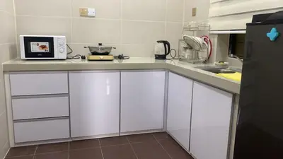 a kitchen with white cabinets and a counter top at My Suites Sri Sayang Resort in Batu Ferringhi