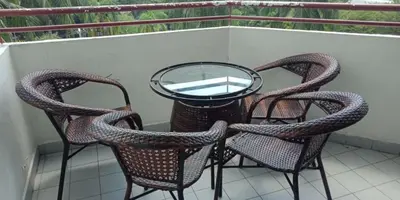 three chairs and a glass table on a balcony at My Suites Sri Sayang Resort in Batu Ferringhi