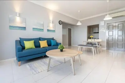 a living room with a blue couch and a table at VIP Suite Seaview Resort Batu Ferringhi 1202 - 3 Rooms in Batu Ferringhi