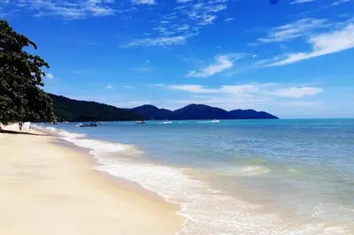a sandy beach with mountains in the distance at VIP Suite Seaview Resort Batu Ferringhi 1202 - 3 Rooms in Batu Ferringhi