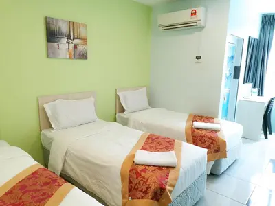 a hotel room with three beds in a room at LH Hotel Langkap Perak in Kampung Degong