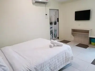 a bedroom with a white bed and a television at LH Hotel Langkap Perak in Kampung Degong