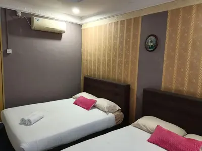 two beds in a hotel room with pink pillows at Hotel Tropicanna Pulai Point in Ipoh