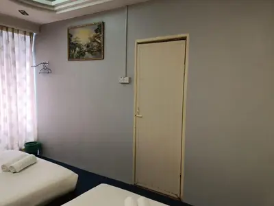 a room with two beds and a closet with a door at Hotel Tropicanna Pulai Point in Ipoh