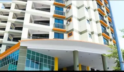a tall white building with orange and white at Marina Height Seaview Resort, Teluk Batik, Lumut in Kampong Tebing Rabak