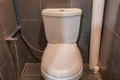 a white toilet in a tiled bathroom at SK Budget Hotel in Jelutong
