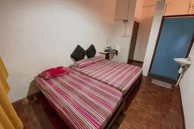 a bedroom with a large striped bed in a room at SK Budget Hotel in Jelutong