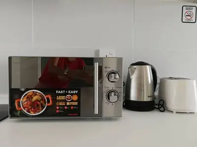 a microwave oven sitting on a kitchen counter at MUJI B&W Studio - Seaview at 218 Tropicana NEAR Komtar Food Heaven with Netflix & TV Box in George Town