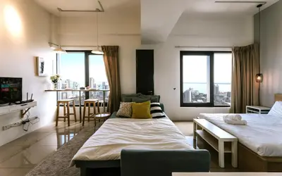 a bedroom with two beds and a table and chairs at MUJI Studio 2 - Seaview at 218 Tropicana Near Komtar Food Heaven with Netflix & TV Box in George Town