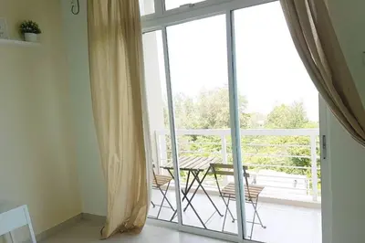 an open door to a balcony with a table and chairs at NEW SEAVIEW Cozy Modern Beach House in Tanjung Bungah
