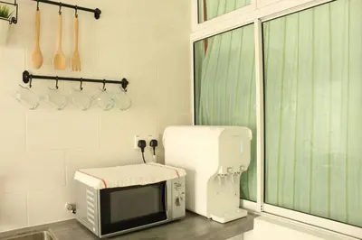 a kitchen with a microwave and a sewing machine at NEW SEAVIEW Cozy Modern Beach House in Tanjung Bungah