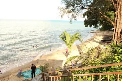 a man standing on a beach next to the ocean at NEW SEAVIEW Cozy Modern Beach House in Tanjung Bungah