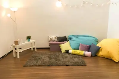 a living room with a couch with colorful pillows at NEW SEAVIEW Cozy Modern Beach House in Tanjung Bungah