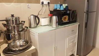 a kitchen with a counter with a coffee pot and a refrigerator at Rose Hill Gardens in Brinchang