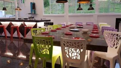 a dining room with a long table and colorful chairs at Rose Hill Gardens in Brinchang