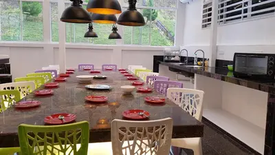 a large dining room with a long table and chairs at Rose Hill Gardens in Brinchang