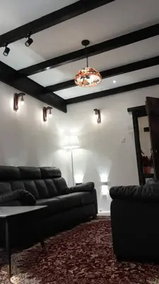 a living room with a couch and a table and a ceiling at Rose Hill Gardens in Brinchang