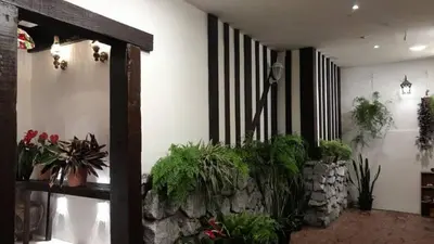a room with potted plants on the wall at Rose Hill Gardens in Brinchang