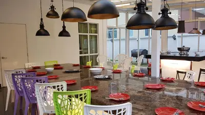 a dining room with a table and chairs and pendant lights at Rose Hill Gardens in Brinchang