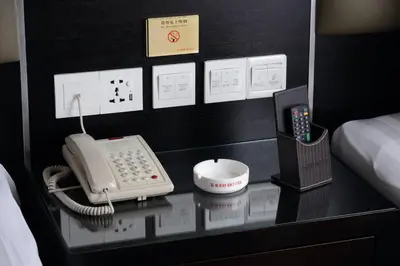 a room with a phone on a glass table at ERNES Hotel in Perai