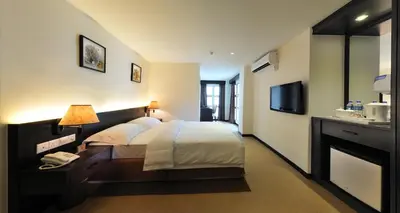 a hotel room with a bed and a television at ERNES Hotel in Perai