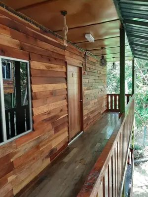 a porch of a log cabin with a wooden wall at Utan Teluk Nipah in Pangkor