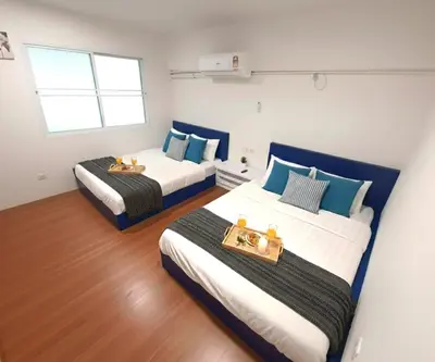 two beds in a room with blue and white at Explore The World at The CEO Studio Penang in Bayan Lepas
